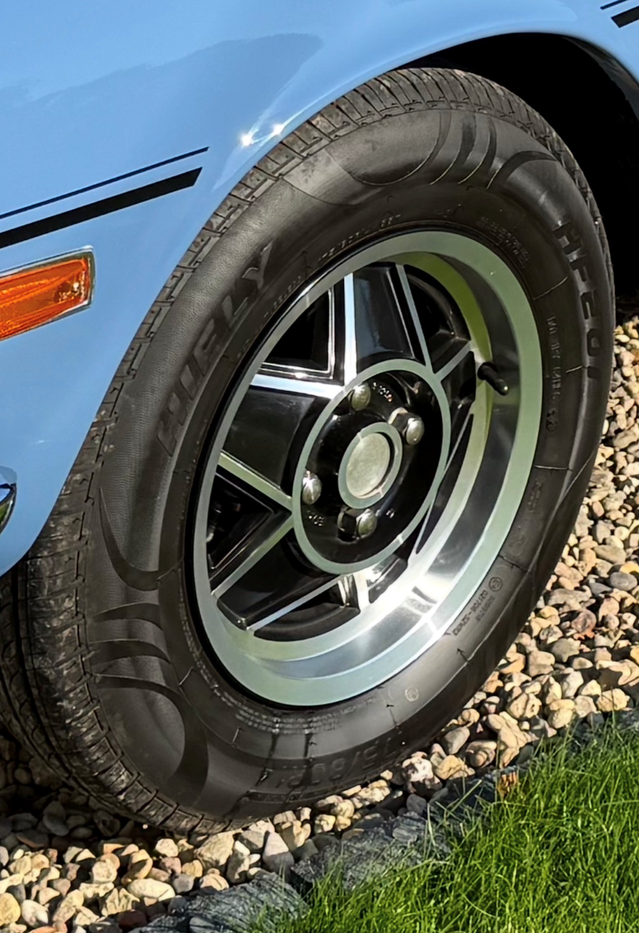 Close-up of a factory-style 14-inch Triumph Stag wheel with correct-profile rubber