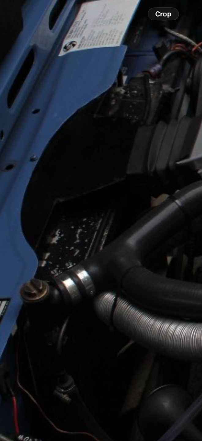 Triumph Stag engine bay showing uprated radiator with hose routing and electric fan boss.