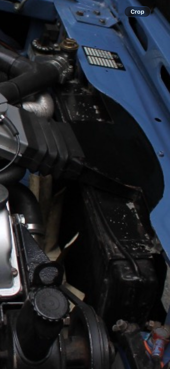 Triumph Stag electric cooling fan and thermostat switch installed in engine bay.