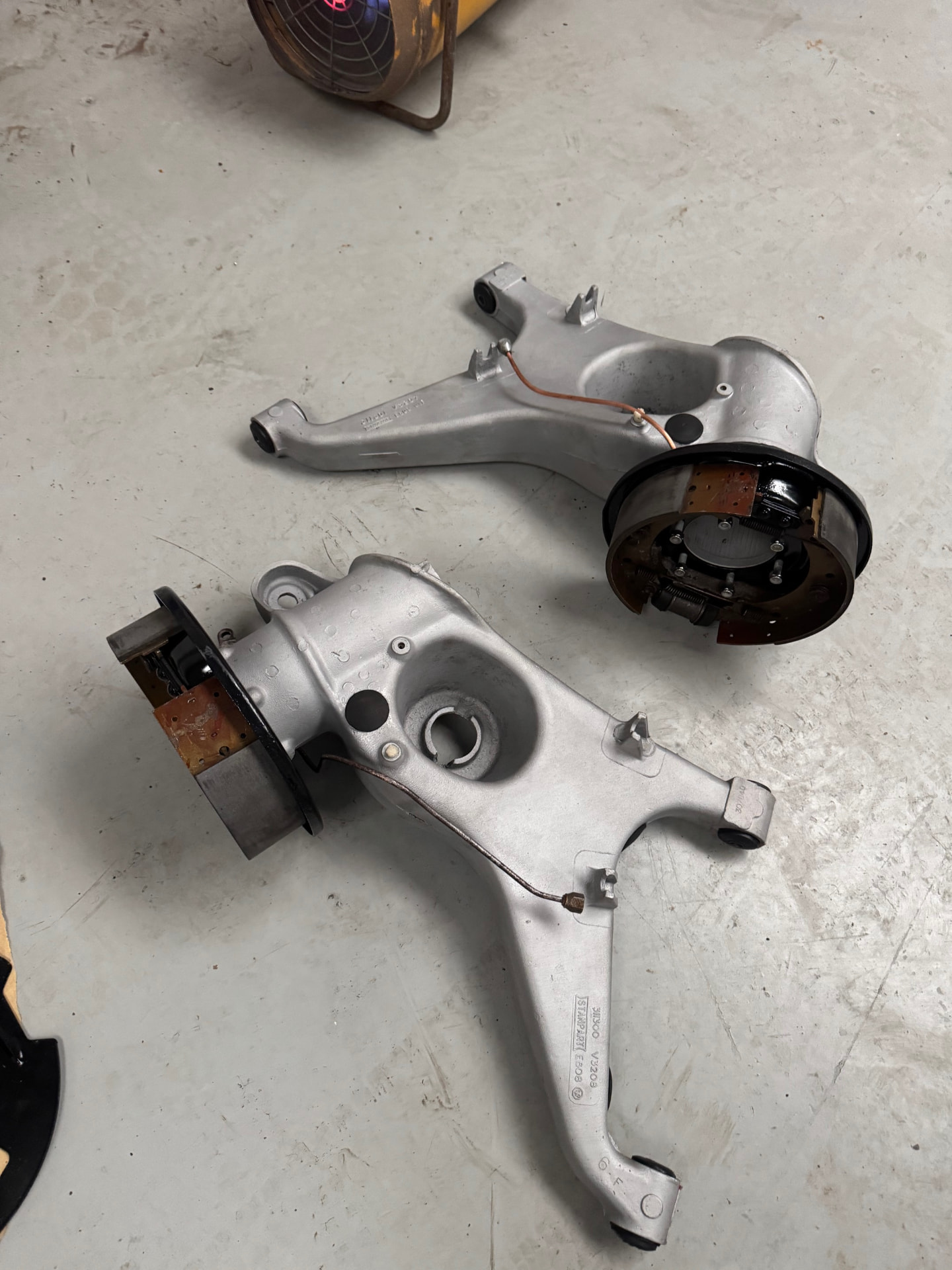 Refurbished rear suspension uprights and brake assemblies laid out during reassembly.
